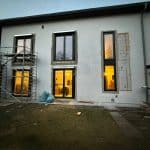 Fenster und Terrassentür bei einem Rohbau montiert. Aussenansicht am Abend.